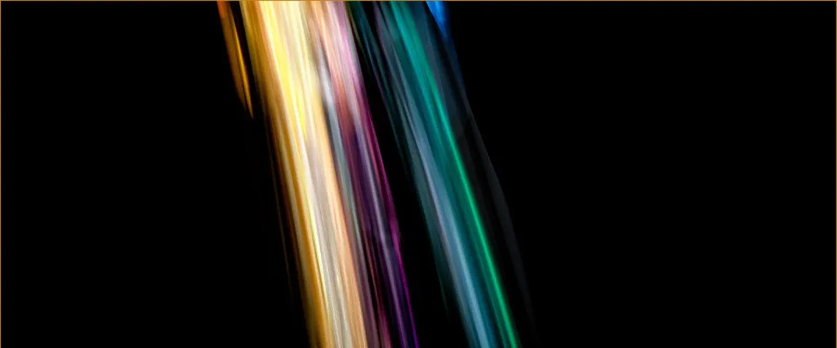 Colourful dice tumbling in streaks of light on a dark background